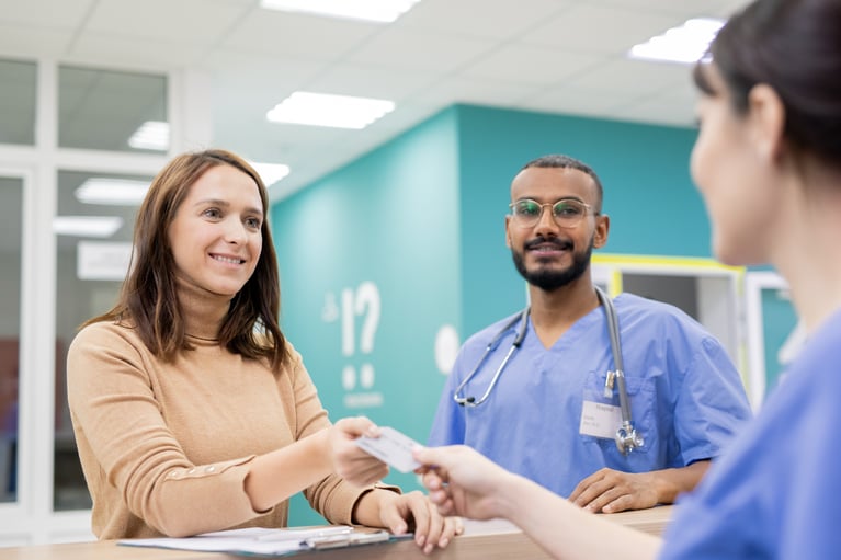 patient-giving-credit-card-to-receptionist-in-clin-2026-01-09-08-10-54-utc